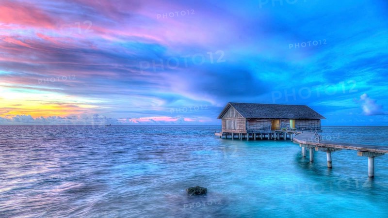Wooden hut on stilts in lagoon