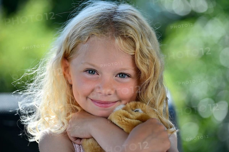 Little girl with blonde hair and cuddly toy
