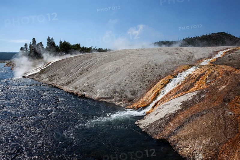 Outlet of the Excelsior Geyser in the Firehole River with mineral deposits