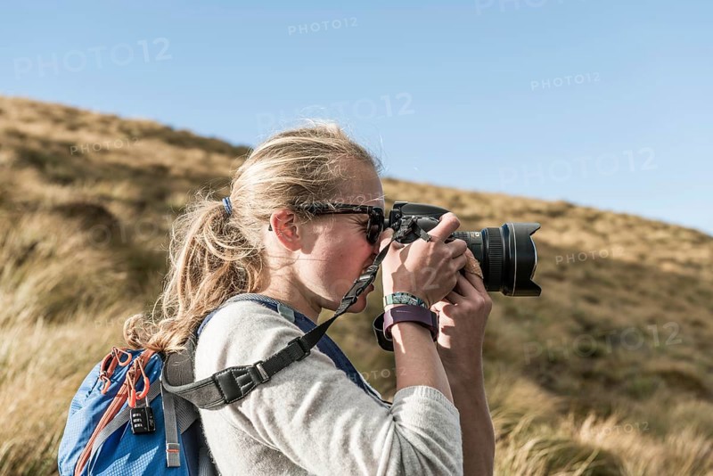 Female hiker taking picture with a reflex camera
