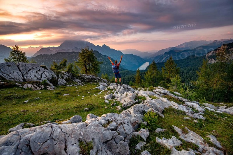 Hiker stretches his arms into the air