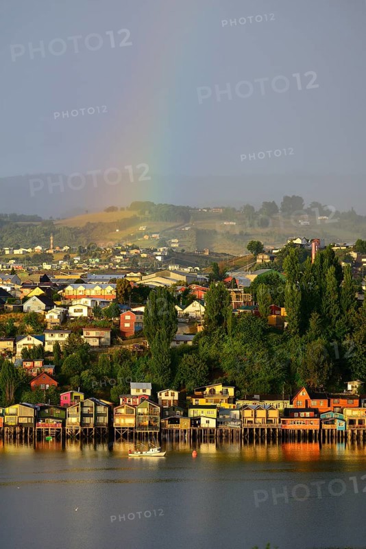 Rainbow over the city with stilt houses