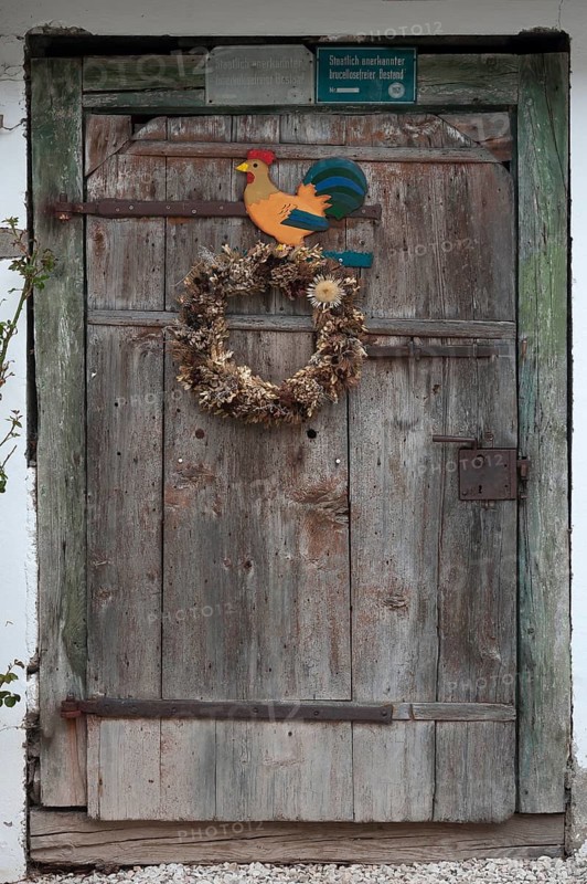 Stable door with a wreath and cock figure