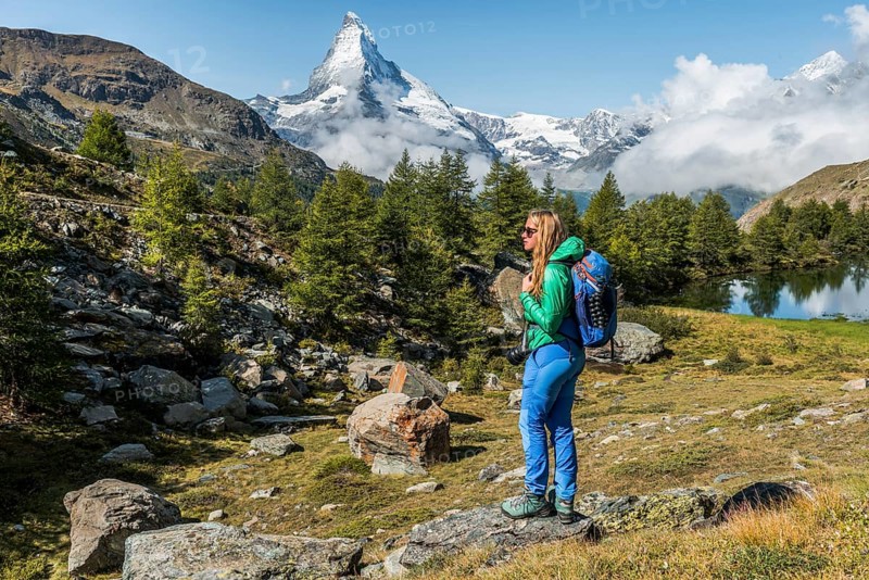 Hiker stands on rocks and looks into the distance
