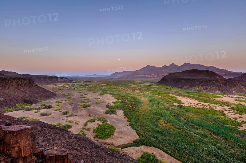 Moon rising in dry river valley