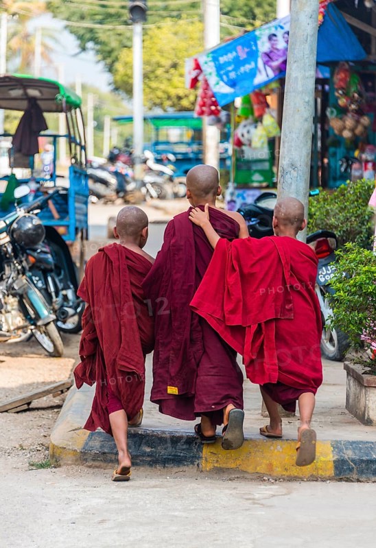 Young Buddhist monks walk on street