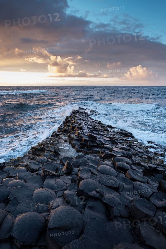 Basalt columns by the coast at sunset