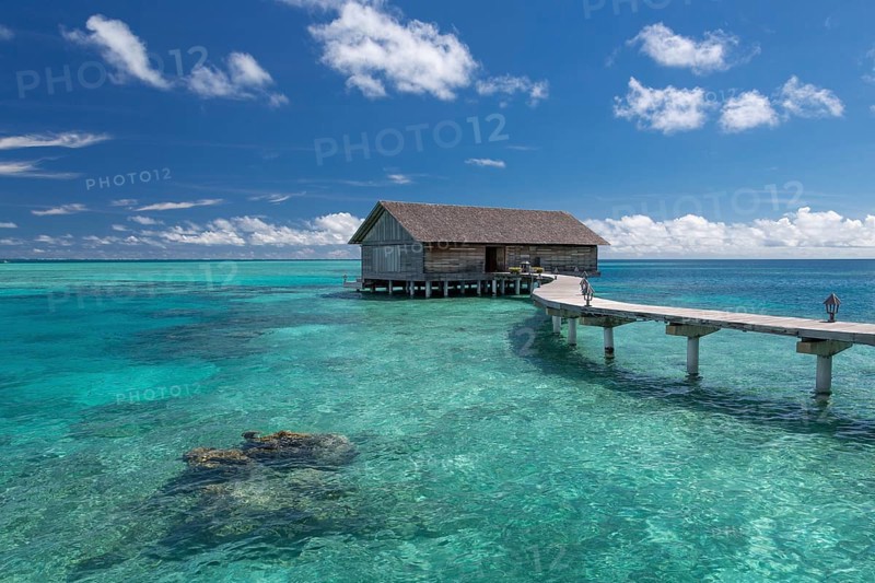 Wooden hut on stilts in lagoon
