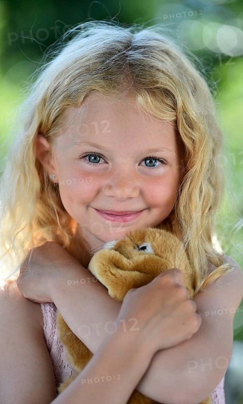 Little girl with blonde hair and cuddly toy