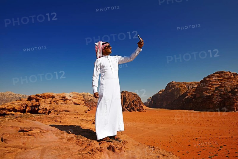 Bedouin uses his smartphone at Rock Arch