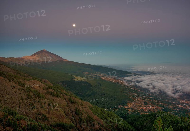 Night view of trade wind clouds over Orotava valley with Pico del Teide in front of sunrise