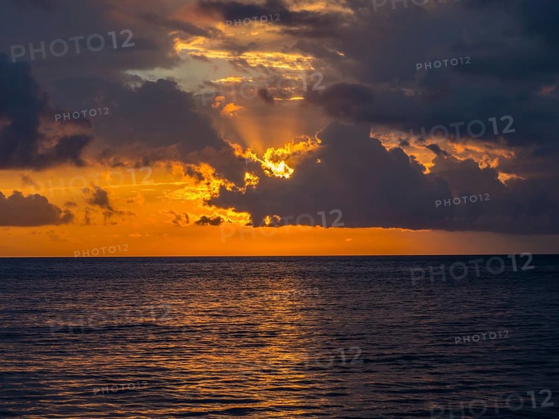 Sunset behind clouds over the sea