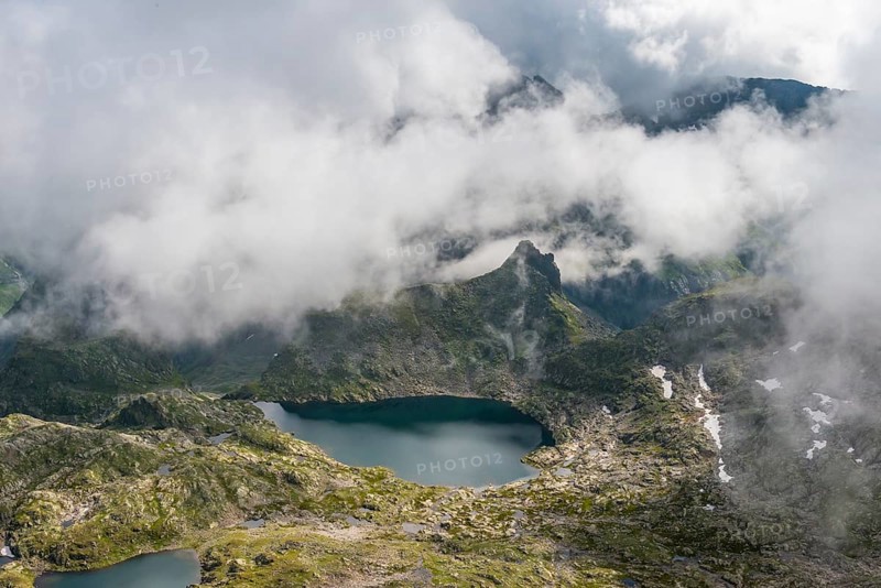 Clouds passing over a ridge by a mountain lake