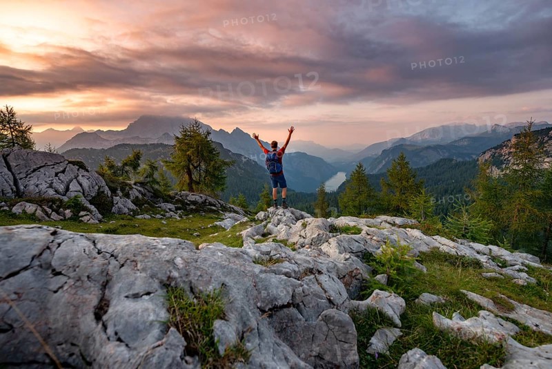 Hiker stretches his arms into the air