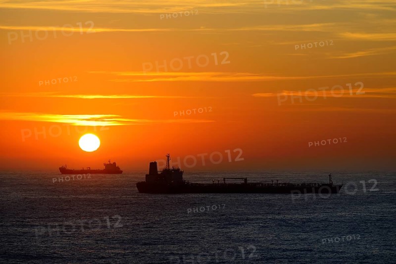 Cargo ships lying on roadstead at sunrise