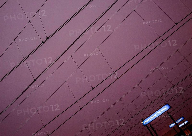 Overhead lines and station sign Amsterdam Centraal at night