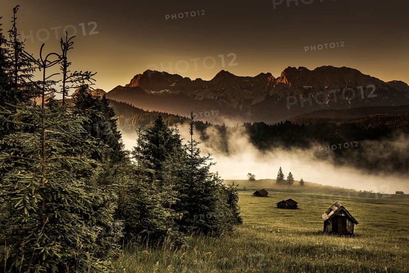Small cabin on mountain meadow at forest edge