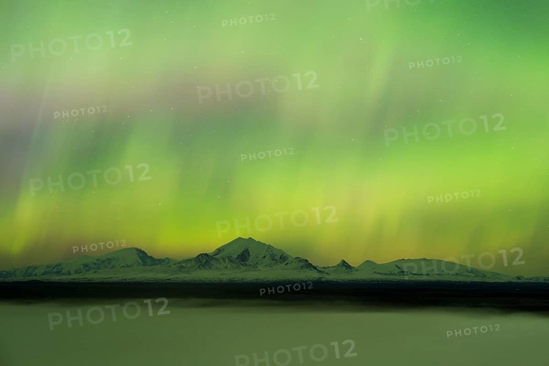 Aurora over the fog shrouded Copper River and mounts Sanford Drum and Wrangell