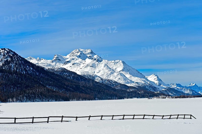 Summit Piz de la Margna above the frozen Lake Silvaplana