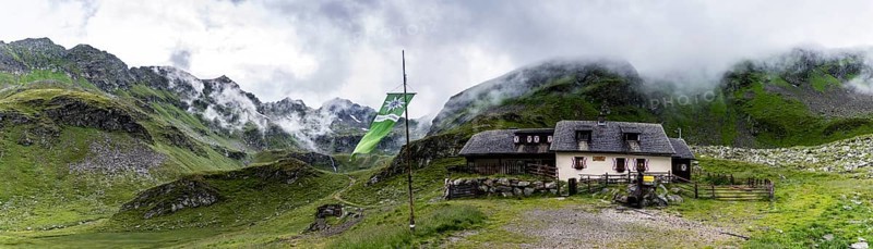 Landawirseehutte and Alpine Club flag with cloudy Alpine valley
