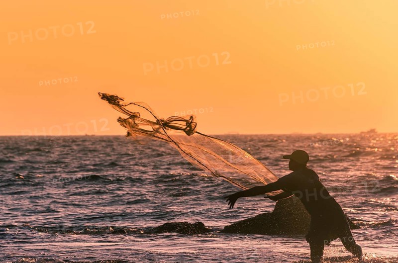 Local fisherman casts fishing net