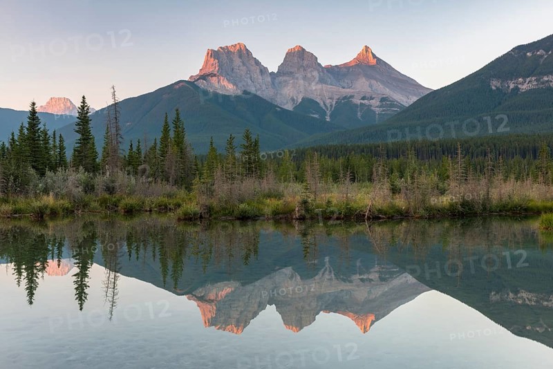 Three Sisters reflecting in calm water