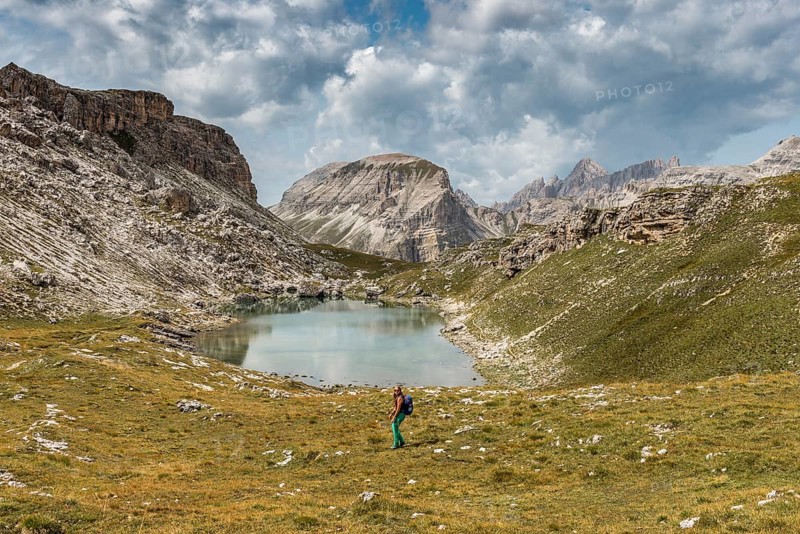 Hiker at the mountain lake Lech de Crespeina