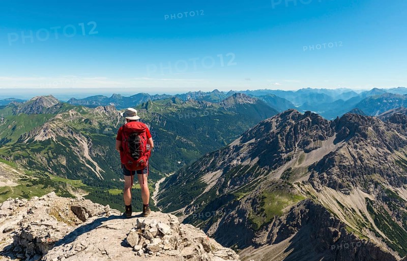 Hikers look out over mountains and alps