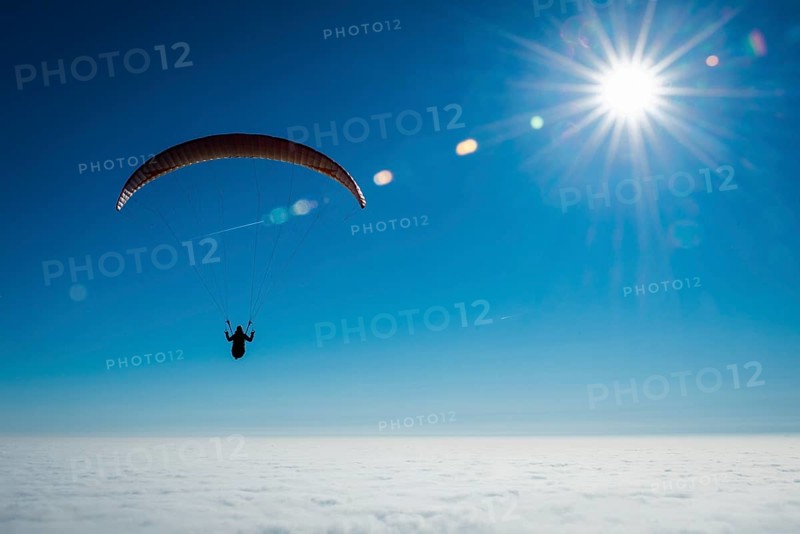 Paraglider over closed cloud cover