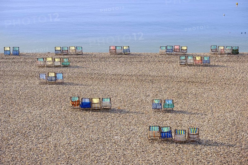 Colorful canvas chairs at the shingle beach