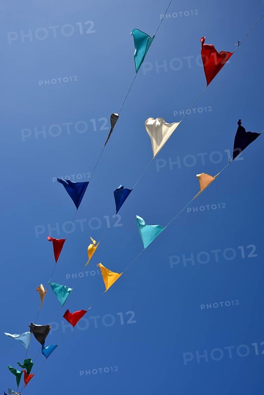 Colorful pennant against a blue sky at a festival