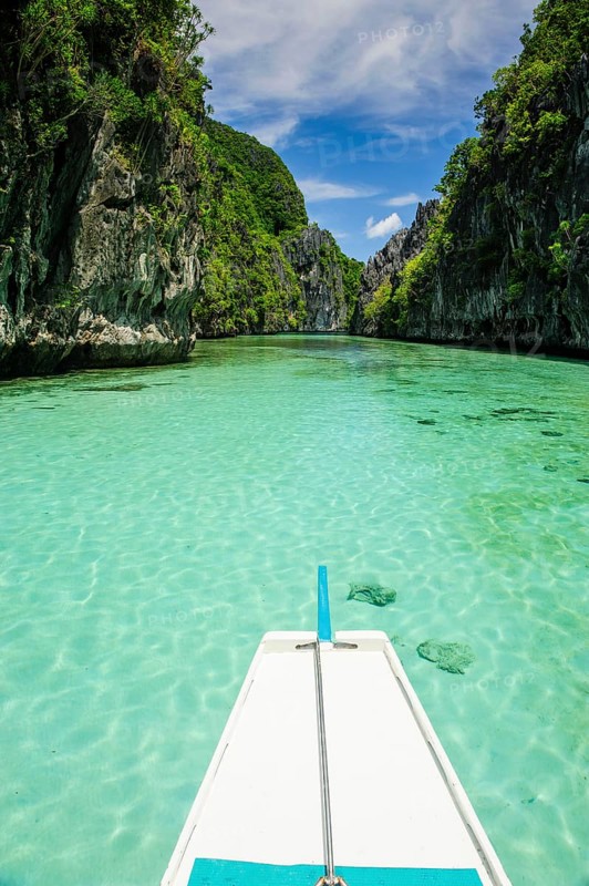 Front of an outrigger boat in the crystal clear water in the Bacuit archipelago