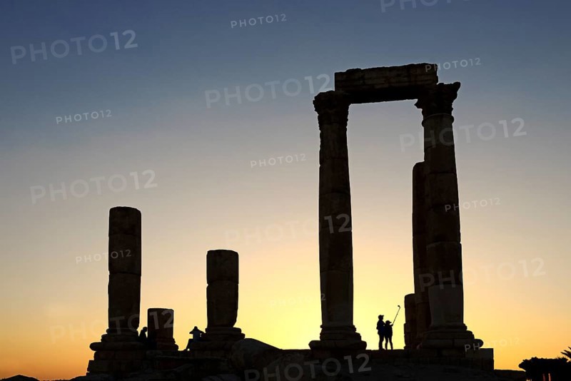 Couple takes pictures with a selfie-stick in sunset at the Temple of Hercules at the Citadel