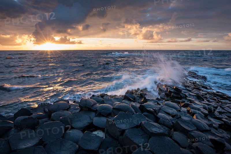 Basalt columns by the coast at sunset