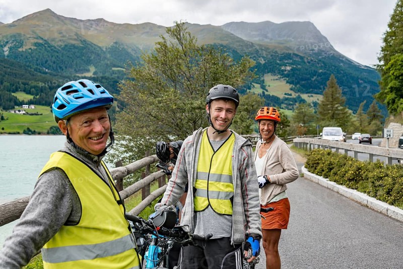 Three cyclists with mountain bikes and safety vest