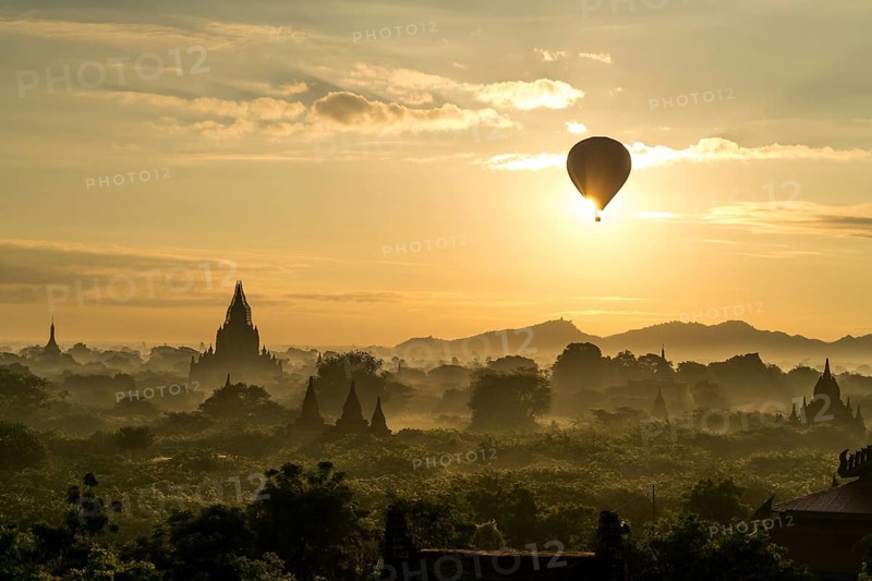 Hot air balloon at sunrise over temples and pagodas