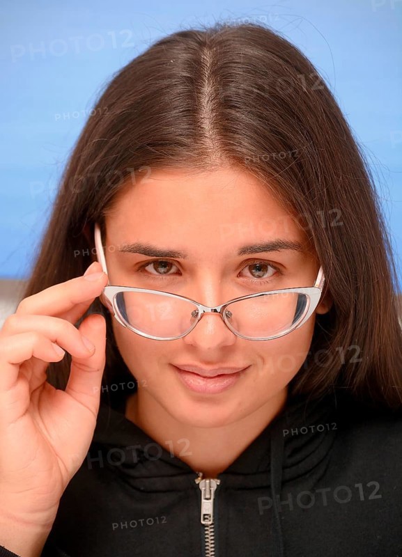 Young dark-haired woman looking over her eye glasses