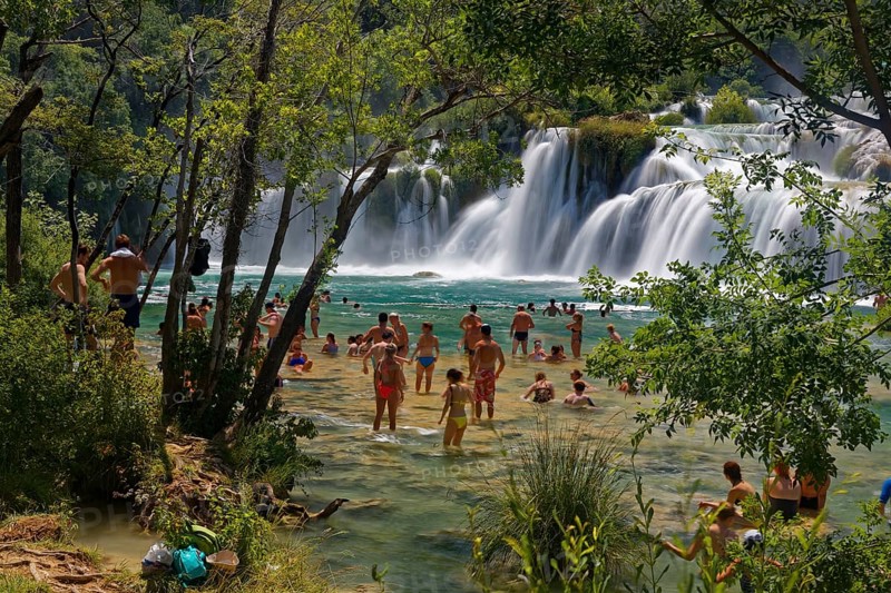 Tourists bathe at the waterfall Smotorcycleinski Buk