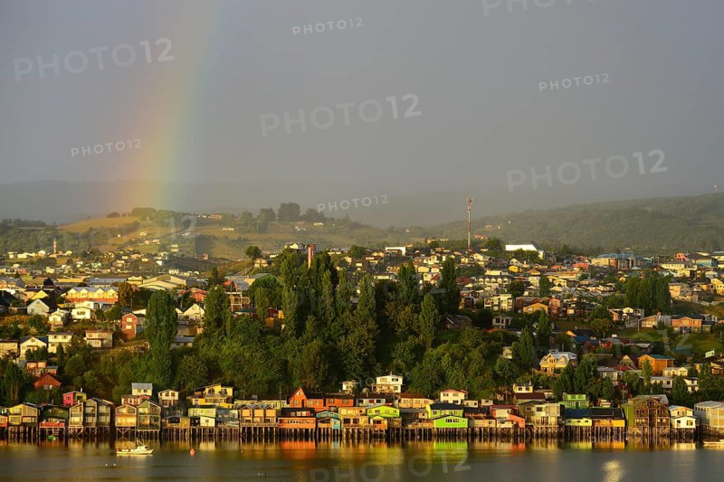 Rainbow over the city with stilt houses