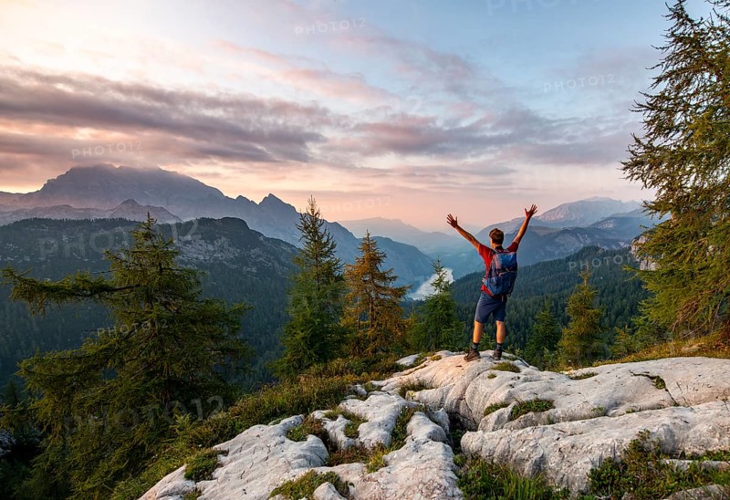 Hiker stretches his arms into the air