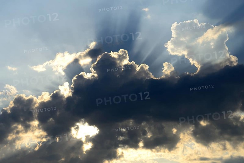 Sun shining behind dark clouds