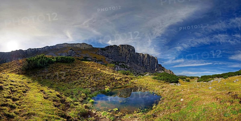 Small mountain lake with Klobenjoch north face