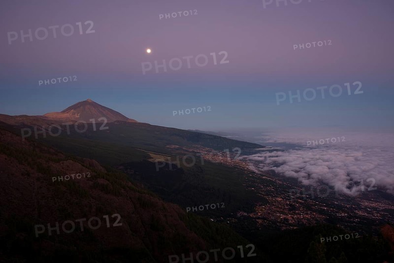 Night view of trade wind clouds over Orotava valley with Pico del Teide in front of sunrise