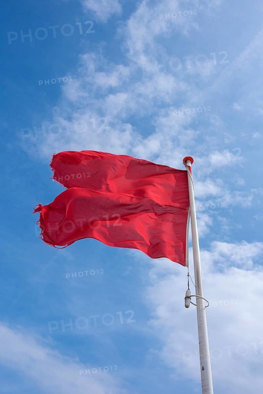 Waving red flag on the beach