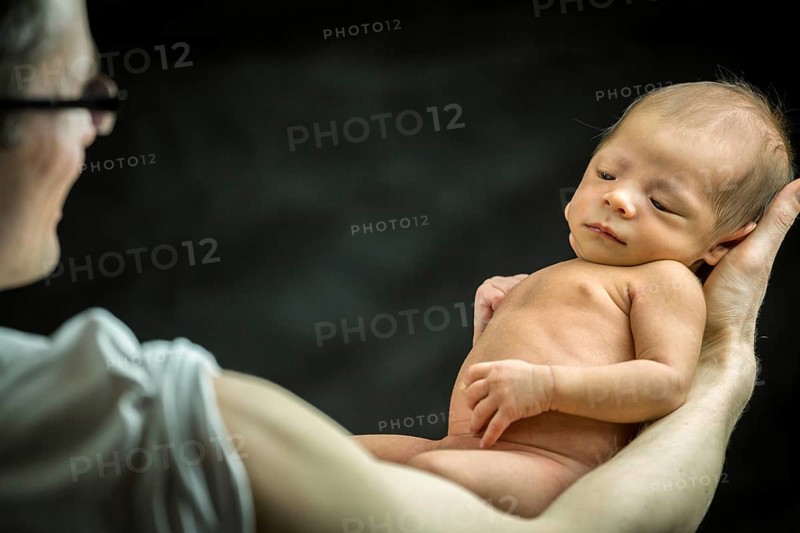 Happy father holding with love his 3 weeks old son