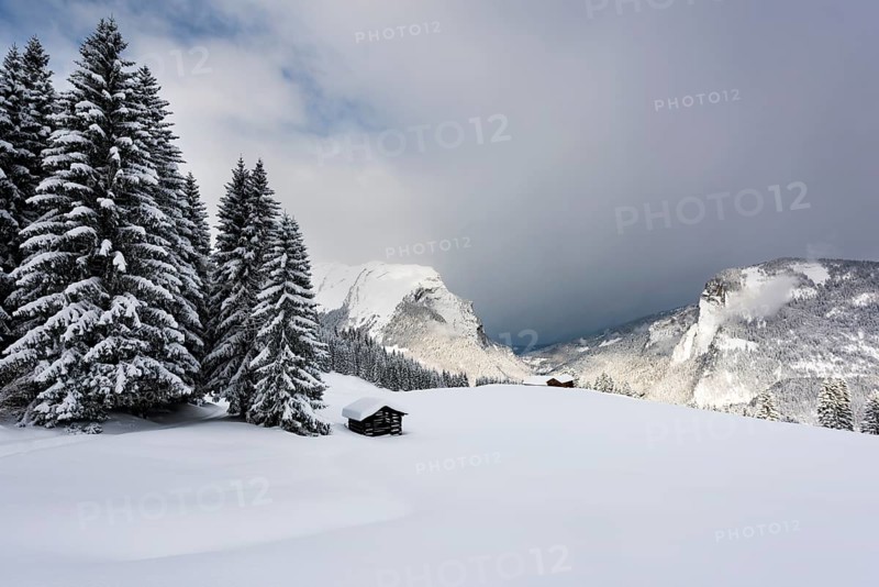 Small country cottage in snowy mountain landscape