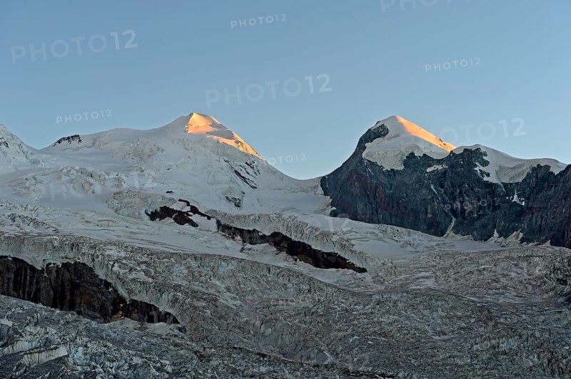 First rays of sunshine at the Castor and Pollux peaks above the border glacier