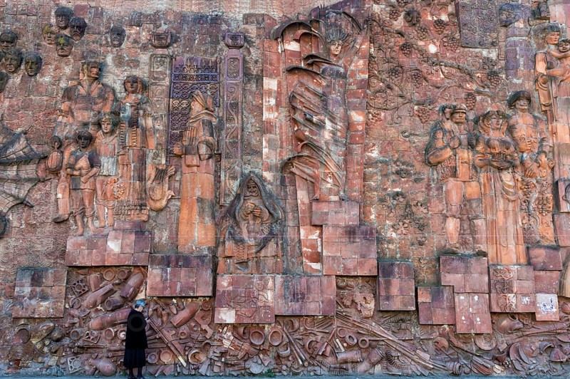 Close-up of faces from communist era on facade of city market