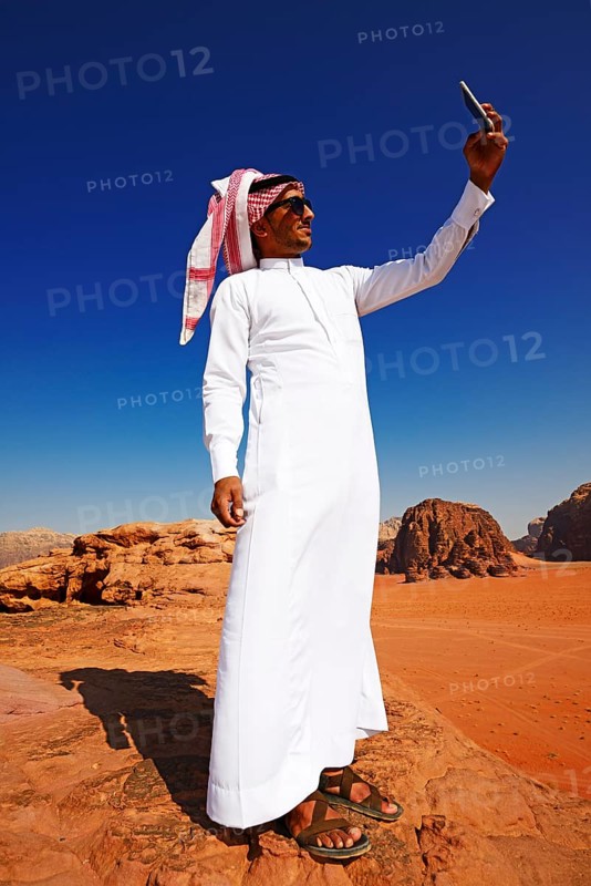 Bedouin uses his smartphone at Rock Arch