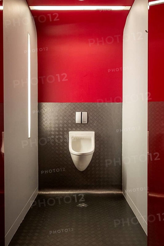 Urinal in modern public toilet nicely illuminated